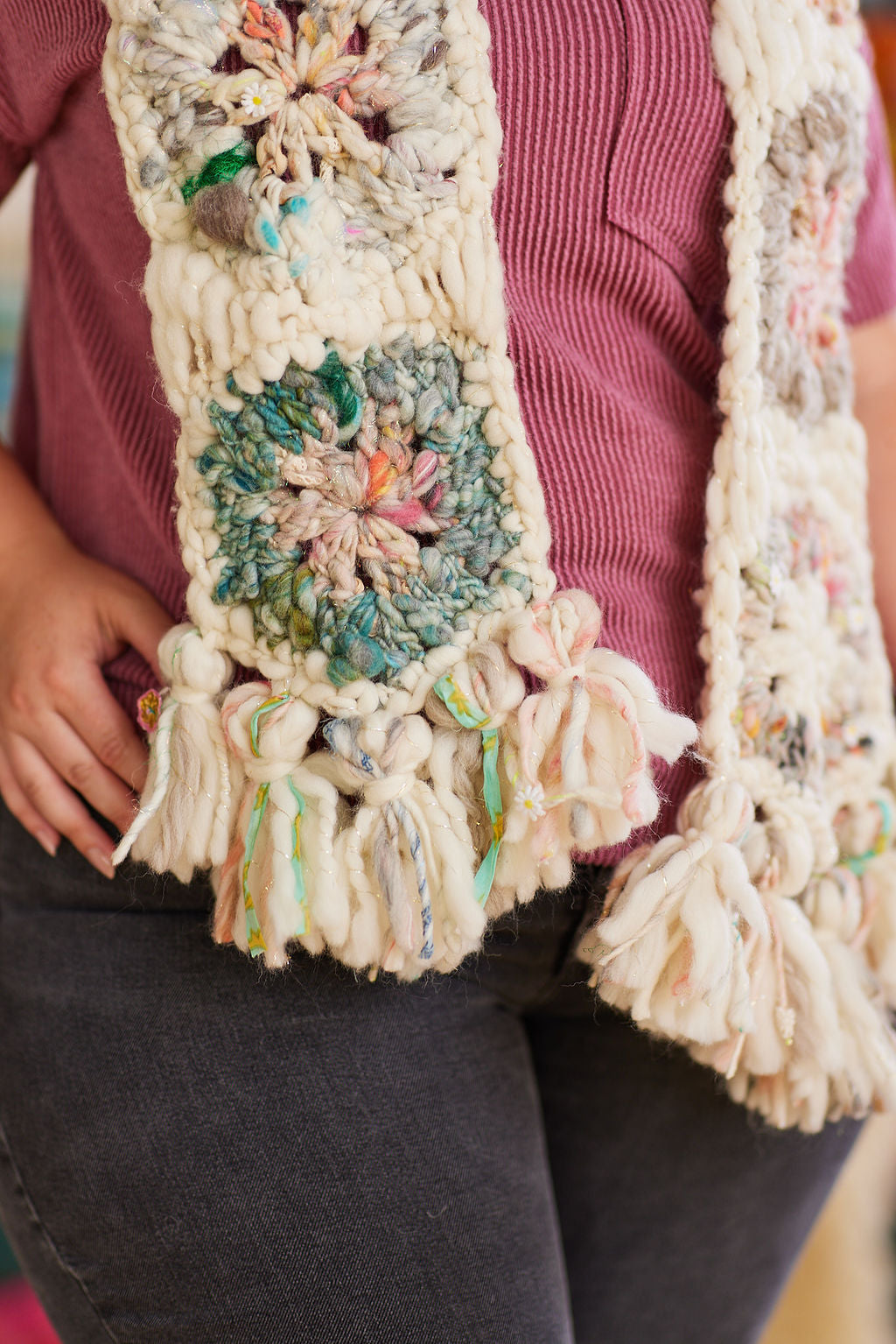 Crochet multicolored hexagon close-up featuring variety of yarns and tassels