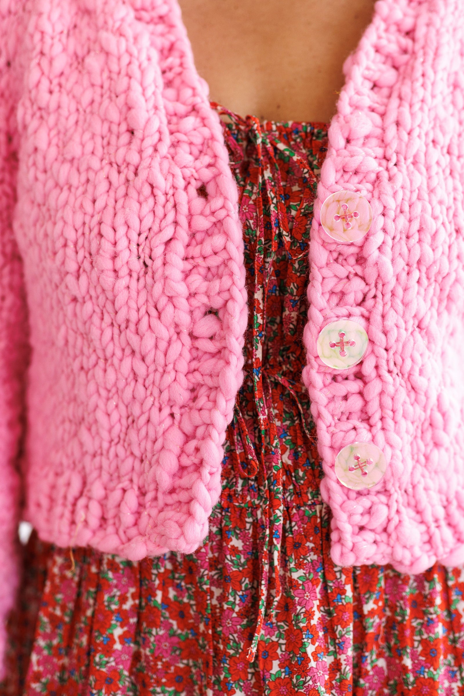 Close-up of three iridescent buttons on bulky knit cardigan.
