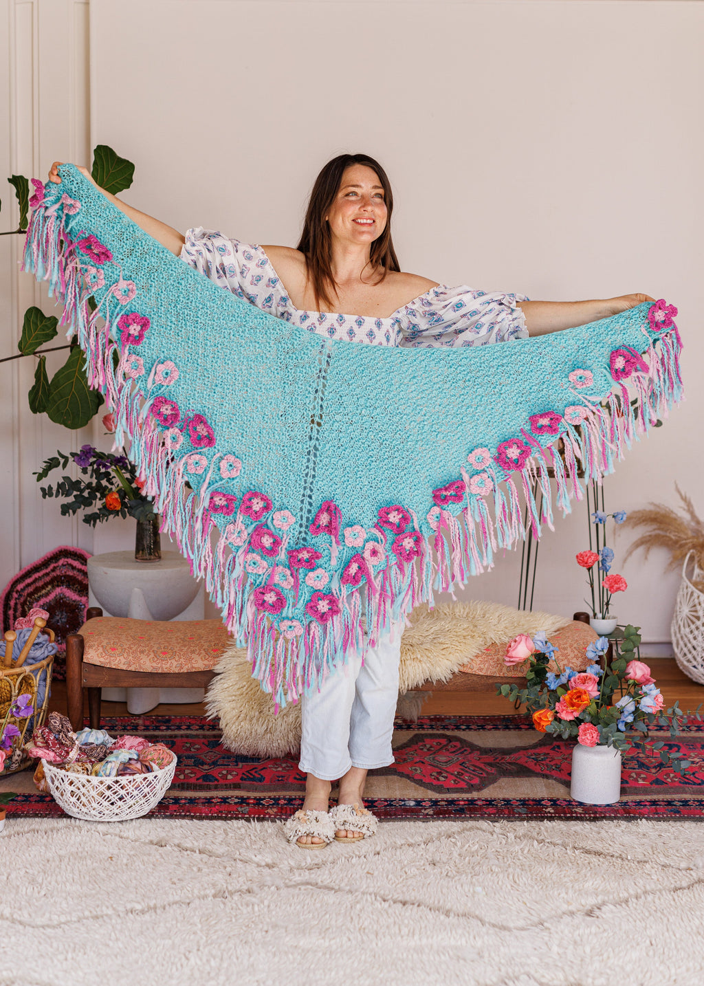 Model smiling while holding shawl in front of her entire wingspan
