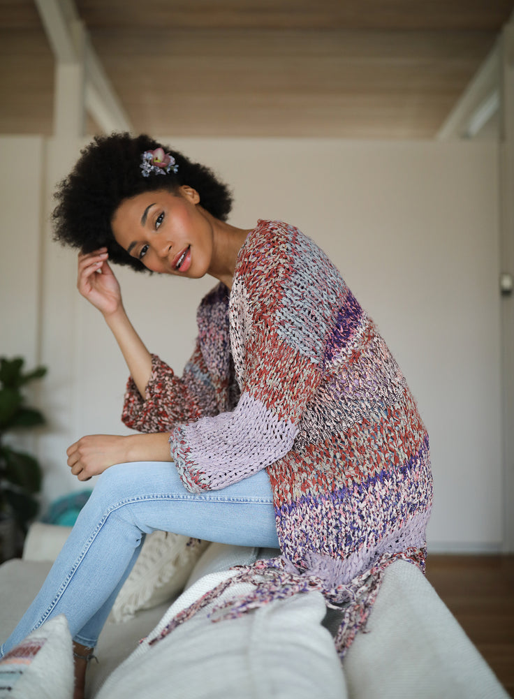 Model touching her hair wearing a cardi.
