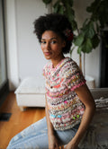 Model sitting on the couch wearing the Kaleidoscope Sweater 