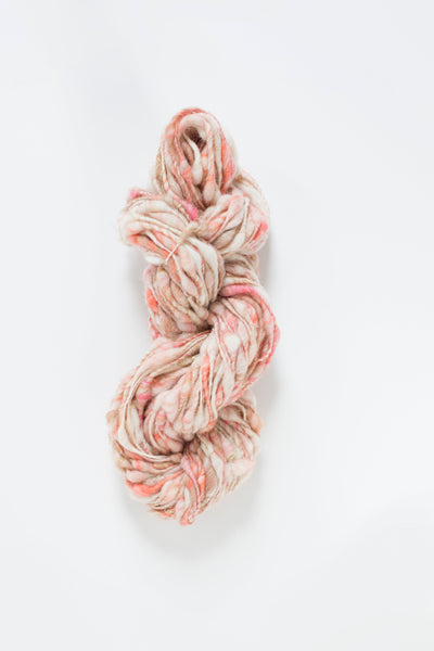 thick-and-thin, core-spun wool yarn in a hand-carded melange of peach, cream, beige and pinks with a subtle silver Angelina sparkle