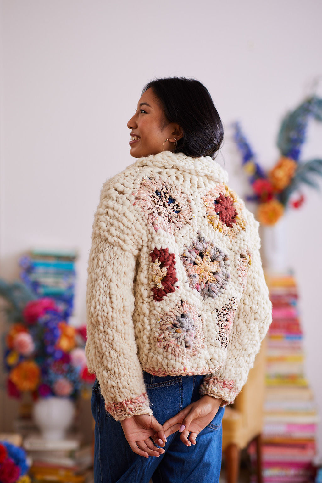 Model displaying  multicolored granny square hexagons on back of cardigan