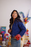 Model displaying front of ink blue cardigan with peony pink wrist cuff detail