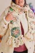 Smiling model wearing textured cream jacket with French Vanilla and multicolored crochet scarf