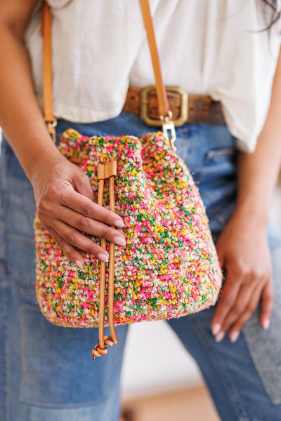 Close-up of model holding drawstring of crochet bucket bug