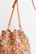Close-up of bucket bag's drawstring, hardware, and strap