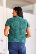 Model showing the back of ice green, short sleeve, knit cardigan  
