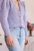 Model wearing periwinkle, puff-sleeve cardigan with 2 of 3 buttons buttoned