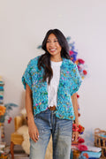 Smiling Model wearing white shirt, denim jeans, brown belt, and the Happy Dance knit cardigan