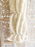 a photo of a scarf knit in a brush boucle yarn in an ivory color, included to show the texture of the stitches