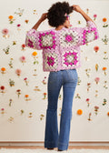 Model with arms bent upward to display back of cardigan and sleeves