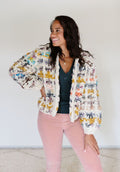 Model smiling with hand on hip wearing a cardi.