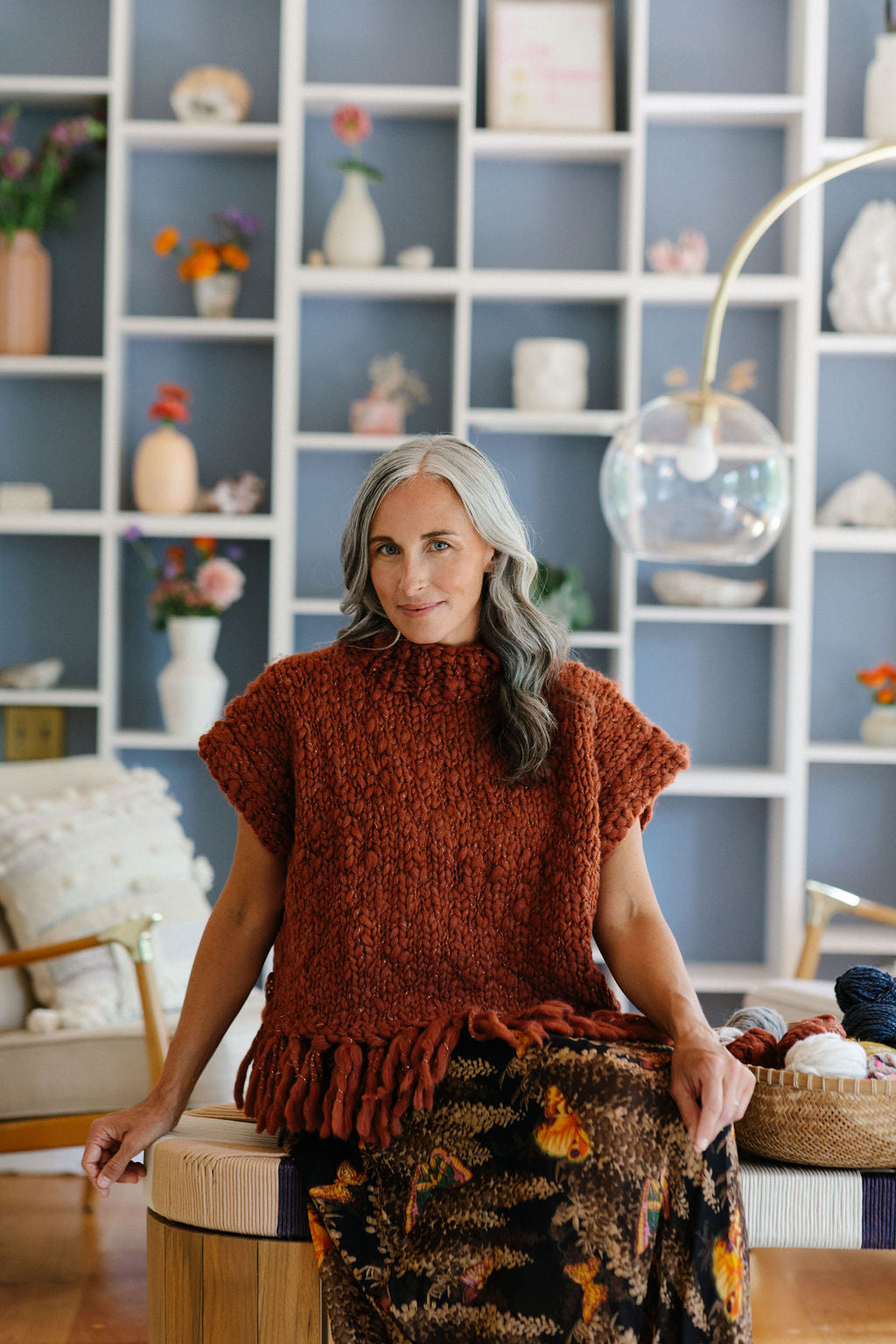 Seated model in cozy handknit Provence Poncho