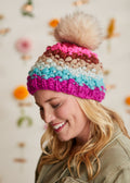 Women smiling facing down while wearing the stitched hat.