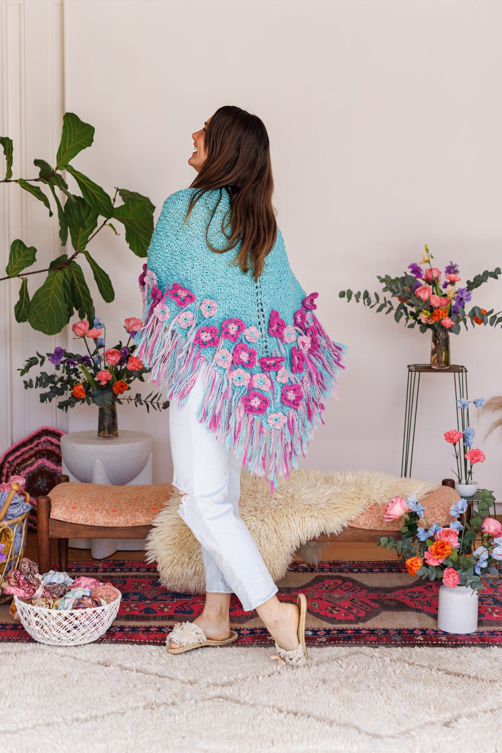 Model twisting to show back of wool shawl