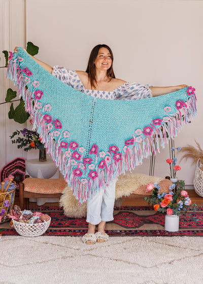Model smiling while holding shawl in front of her entire wingspan