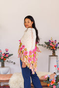 Model twisting to show back of knit shawl over shoulder, displaying center back detail of triangle shawl