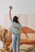 Woman wearing a cardigan with the word 'knitter' embroidered in cursive