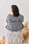 Handknit cardigan with the word 'twirl' handstitched on the back.