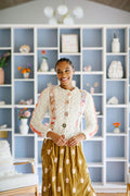 Woman wears a buttoned up cabled cardigan over a dress