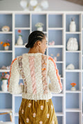 The back of the Winding Road Cardigan shows off three columns of cables in different yarns