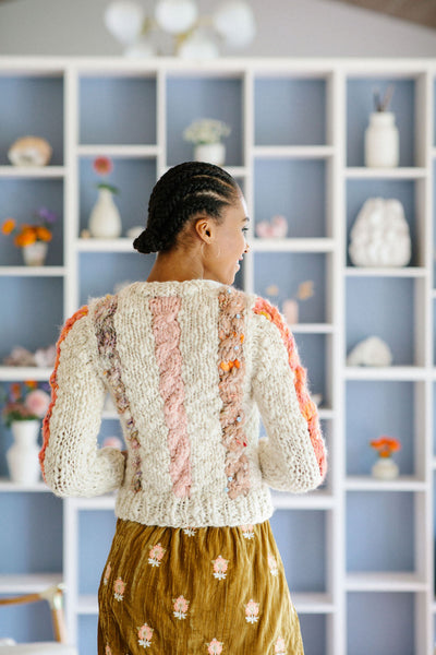 The back of the Winding Road Cardigan shows off three columns of cables in different yarns