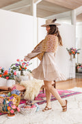 Model turns to display repeating lace pattern on multicolor knit wrap