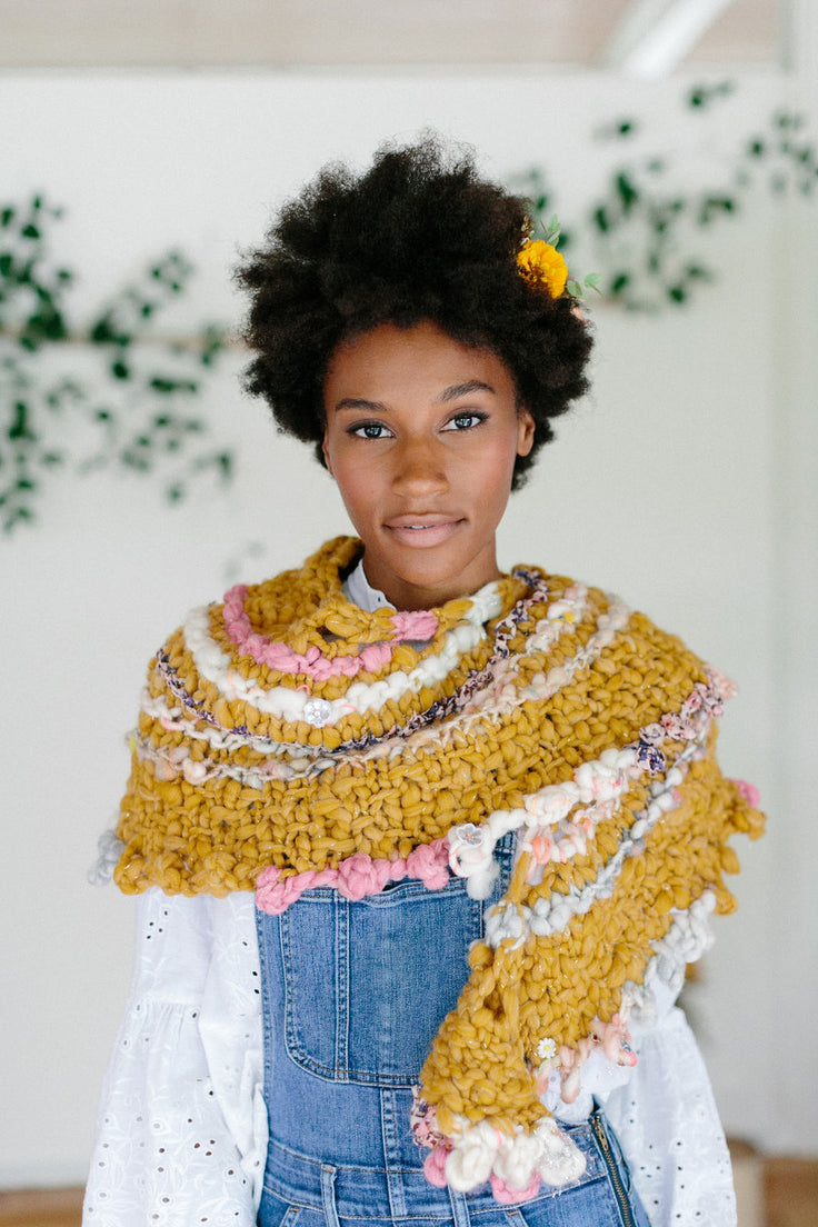 Model looking straight ahead wearing shawl .