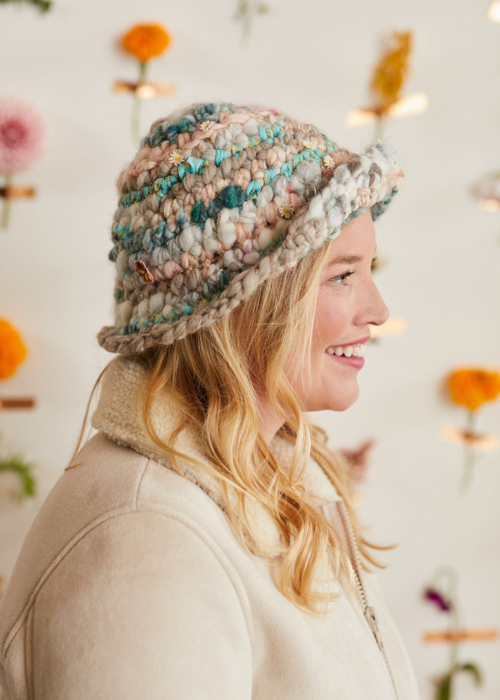 Crochet bucket hat in different colors being modeled by a woman.