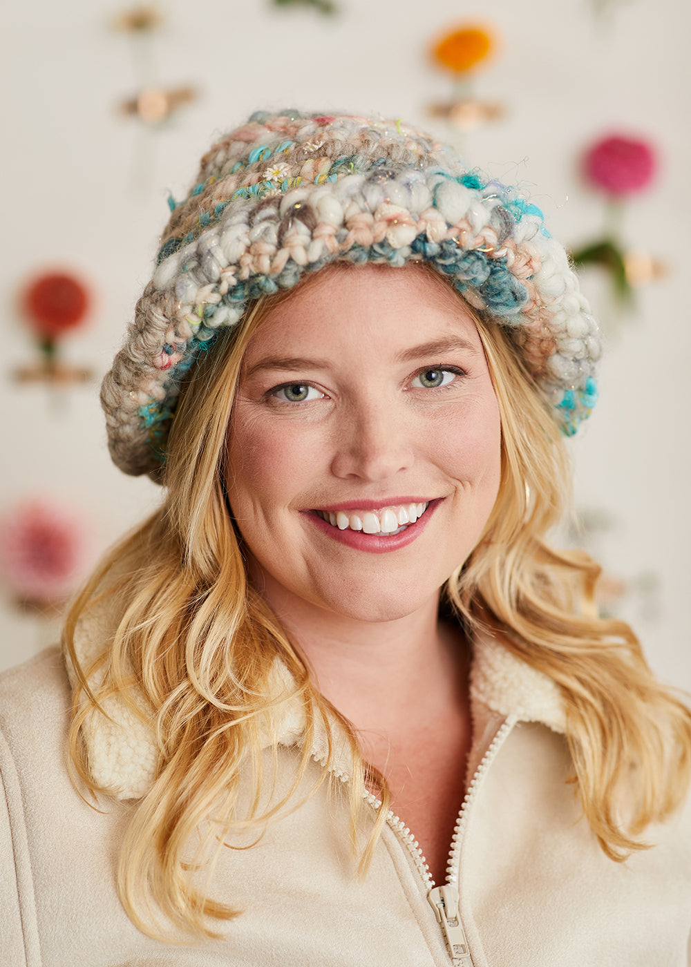 Model wearing a crochet wool bucket hat with brim folded up.