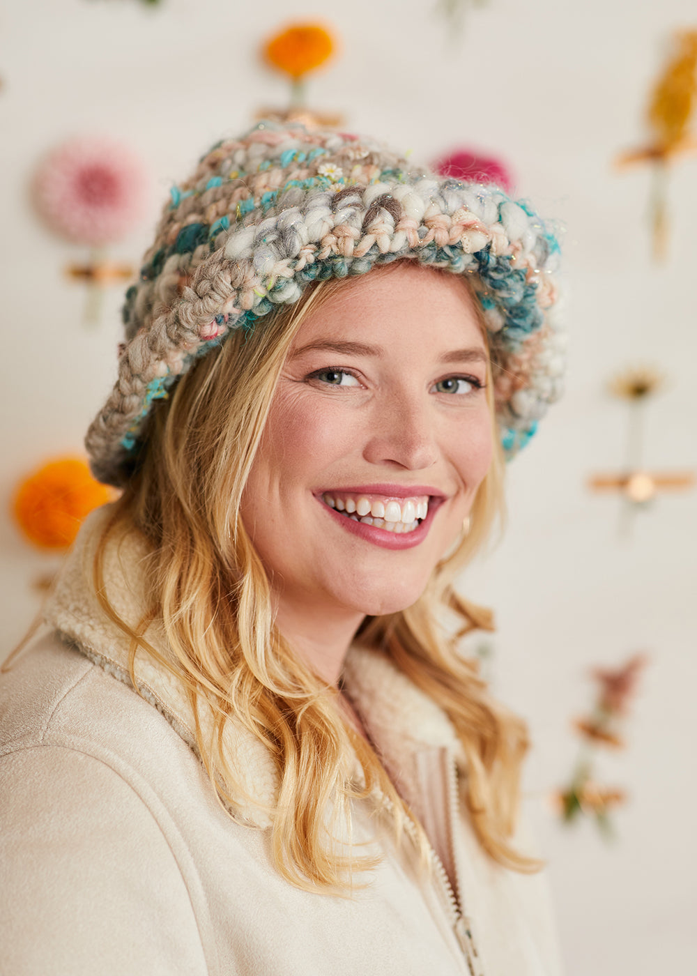 Model smiling at the camera while wearing the Fall Bouquet Bucket Hat