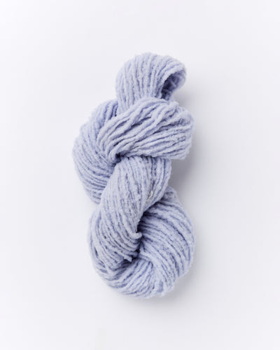 A skein of brushed boucle yarn in a periwinkle blue purple color