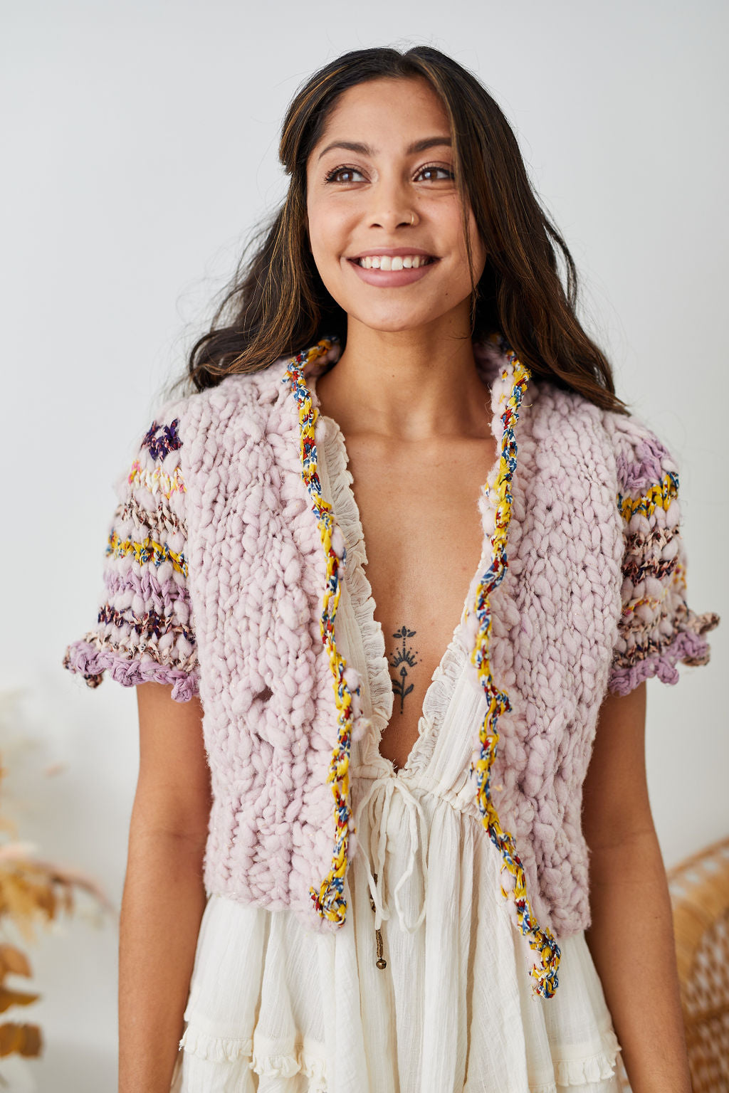 Model smiling wearing cardi over summer dress.