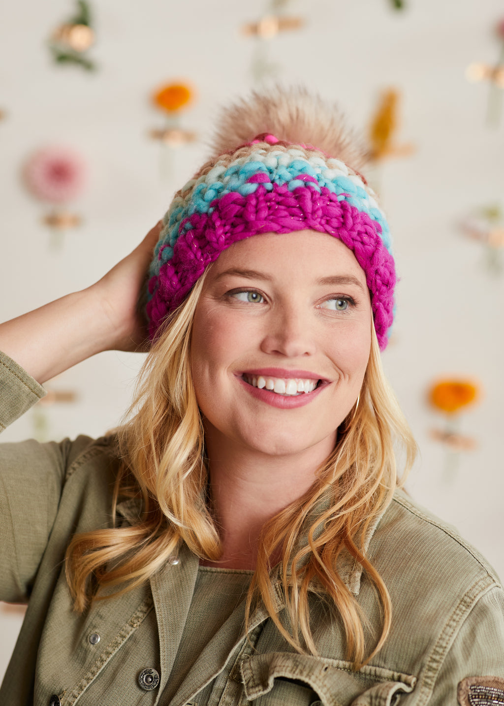 Woman wearing a knit wool hat and smiling at the camera.