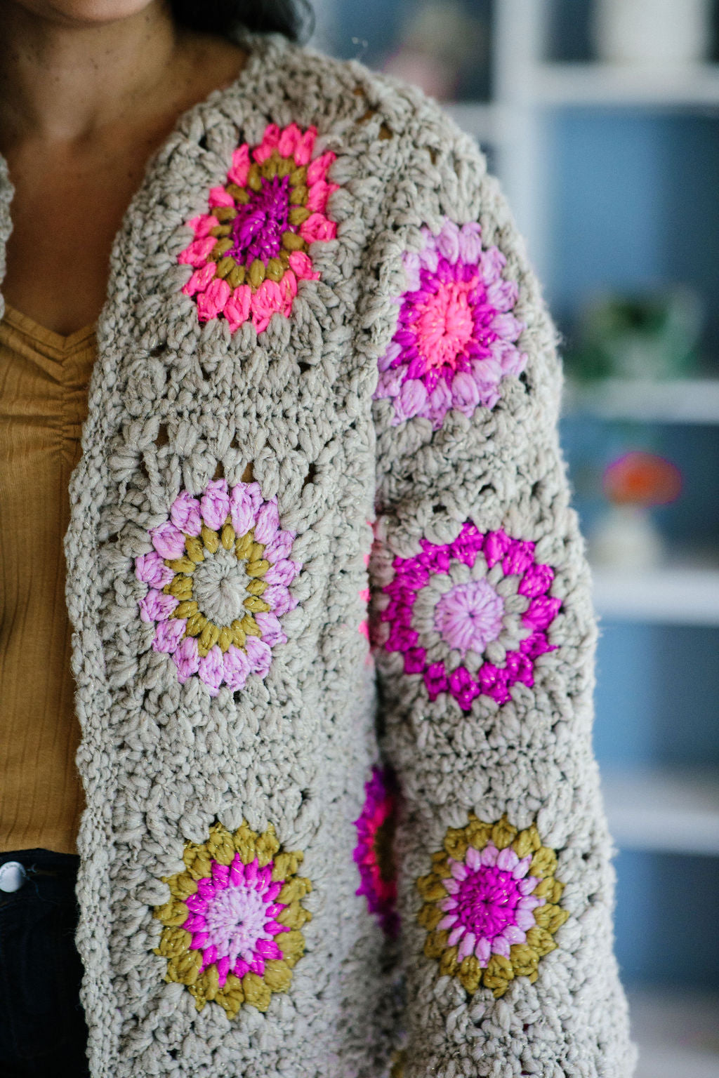 Close up of the front panel and arm showcasing the brightly colored starburst granny squares