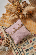 Pillow with the word "Exhale" embroidered on it.