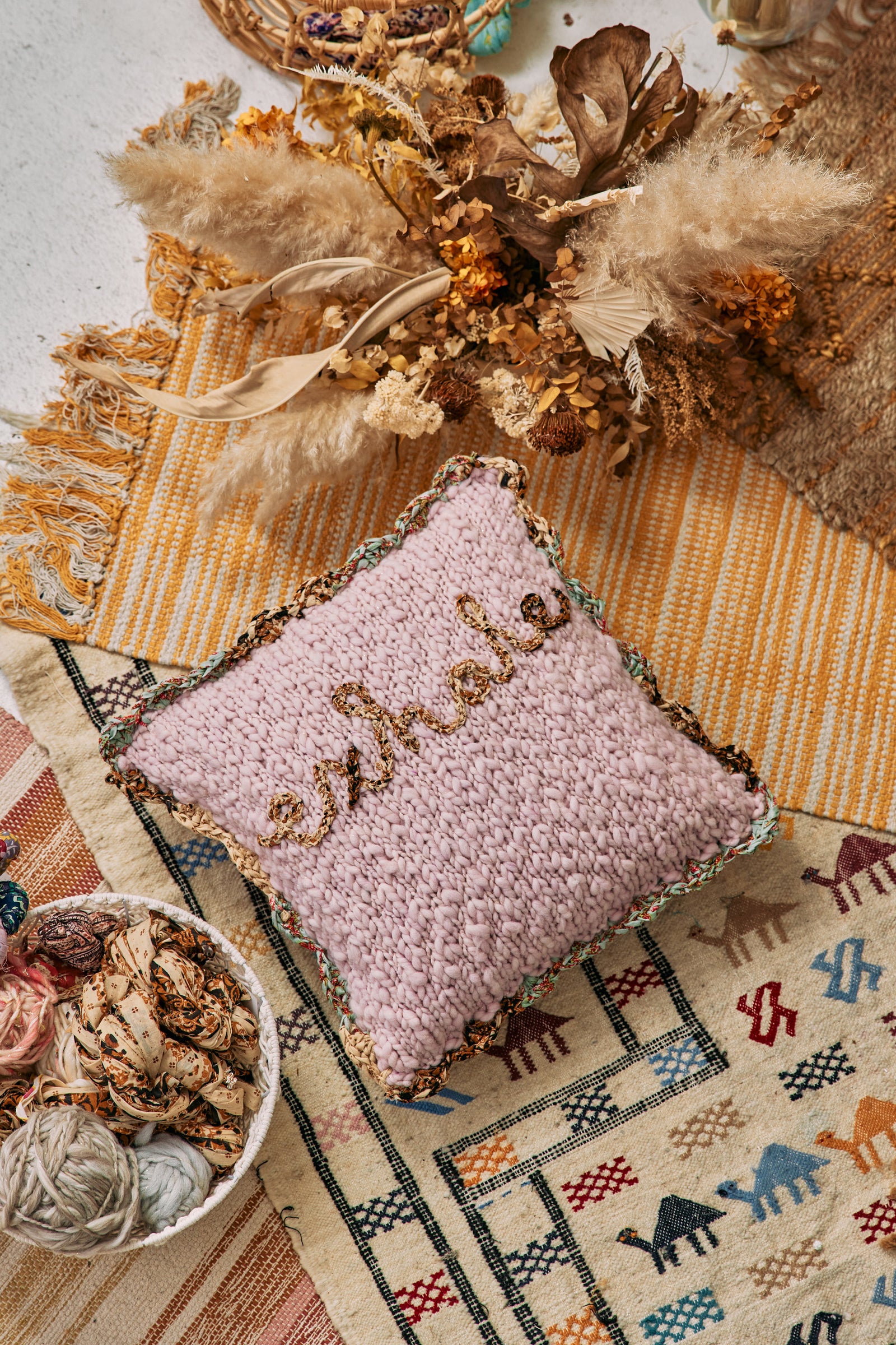 Pillow with the word "Exhale" embroidered on it.